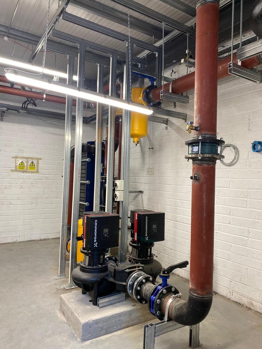 Pump set and riser pipework being investigated in a plant room
