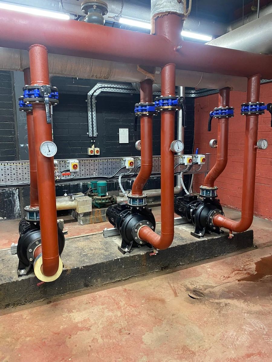 Copper headers, gauges and isolating valves on a plant room wall